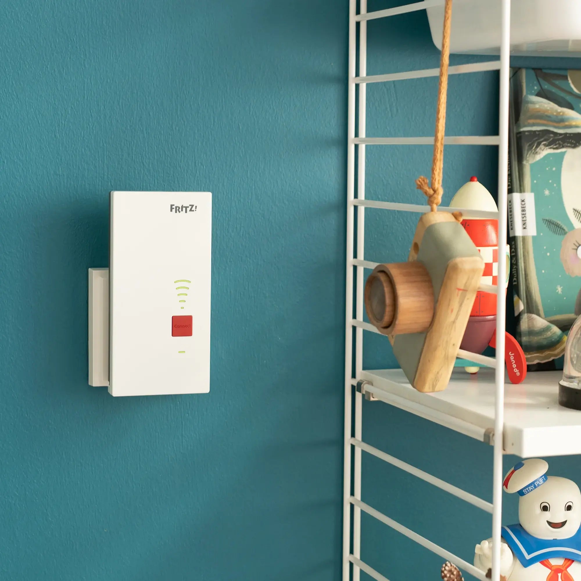 FRITZ!Mesh Set 2700 an Wandmontage mit dekorativen Elementen und Regal im Hintergrund