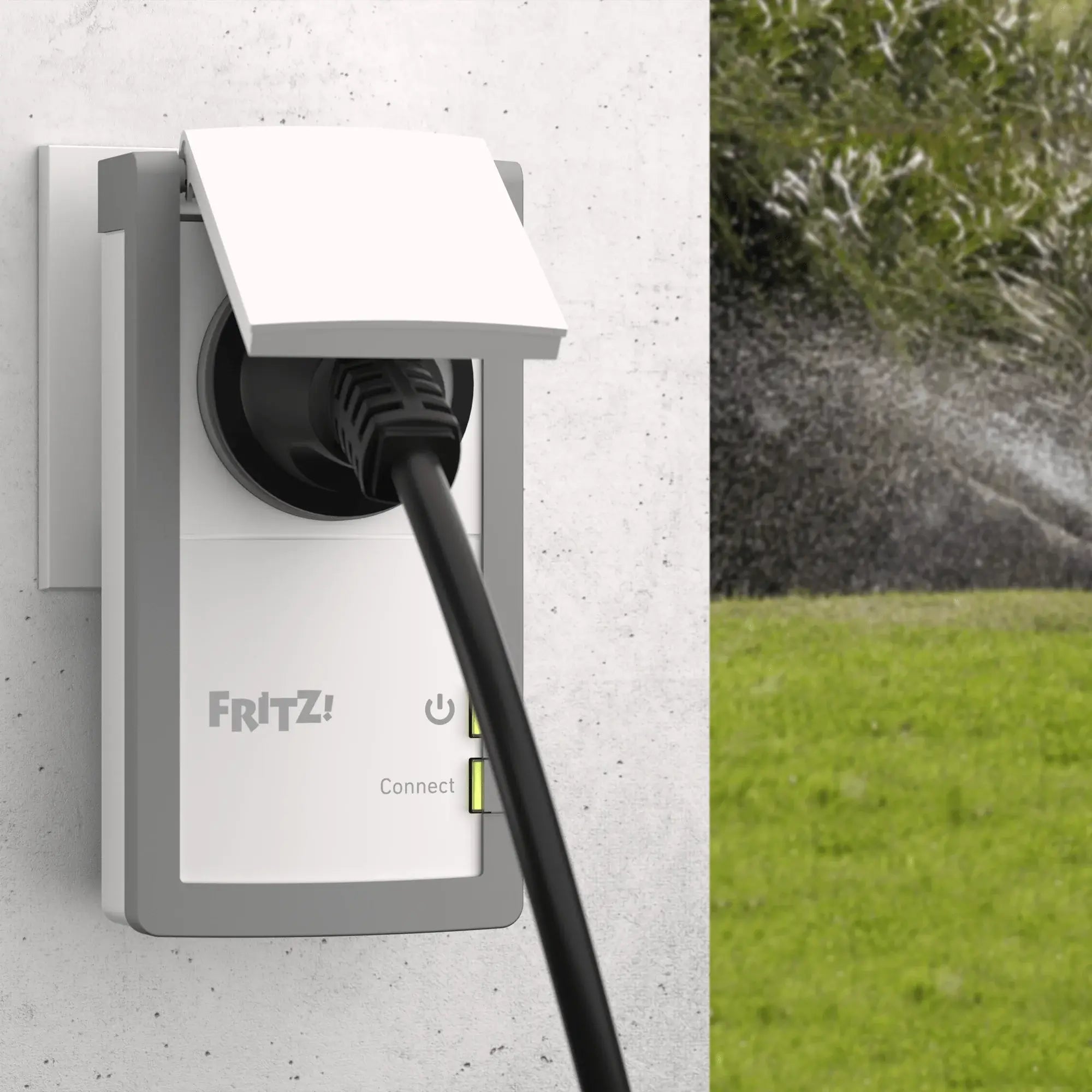 FRITZ!Smart Energy 210 an Wandsteckdose eingesteckt, Blick in Garten