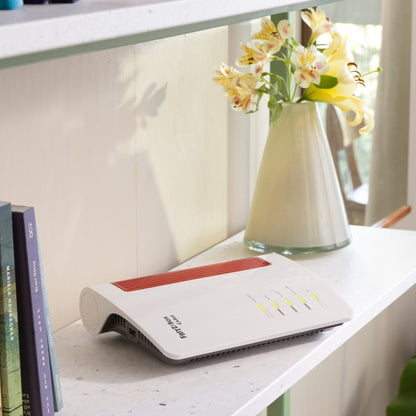 FRITZ!Box 6670 Cable router on a shelf with books, offering Wi-Fi 7 for enhanced streaming and gaming.