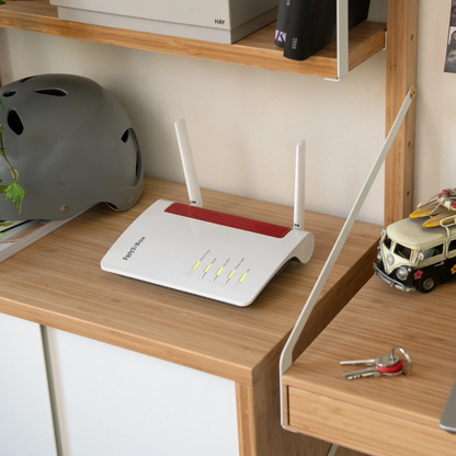 FRITZ!Box 6850 4G Router auf Holzregal, ideal für mobiles Internet mit 4G, WLAN und DECT-Basis.