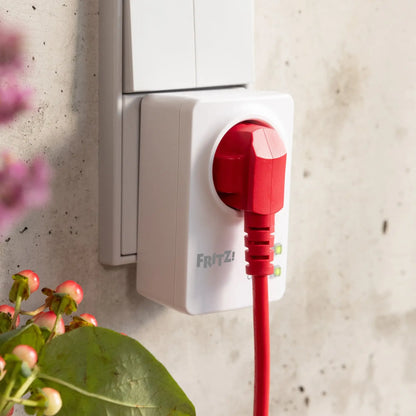 FRITZ!Smart Energy 200 Steckdose mit rotem Stecker, installiert in einer Wandsteckdose.
